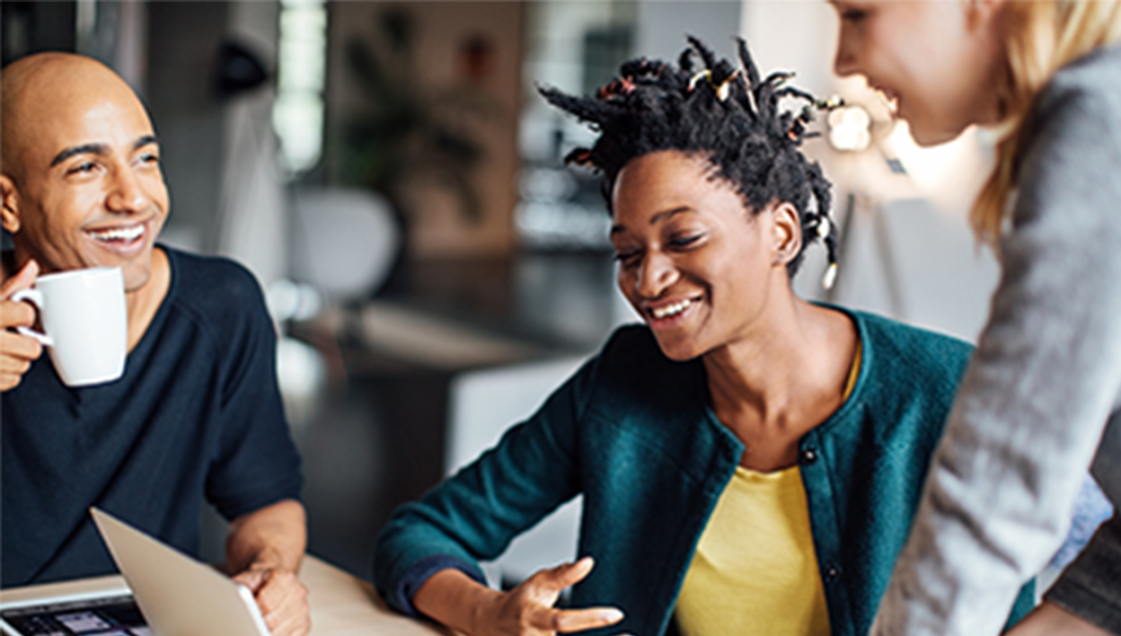 a group of coworkers sitting around a conference table having a meeting