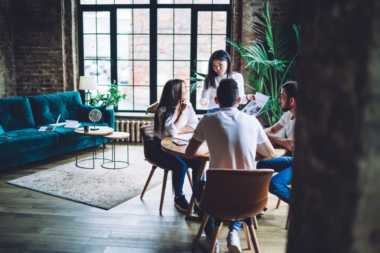 Young diverse colleagues communicating in modern loft office