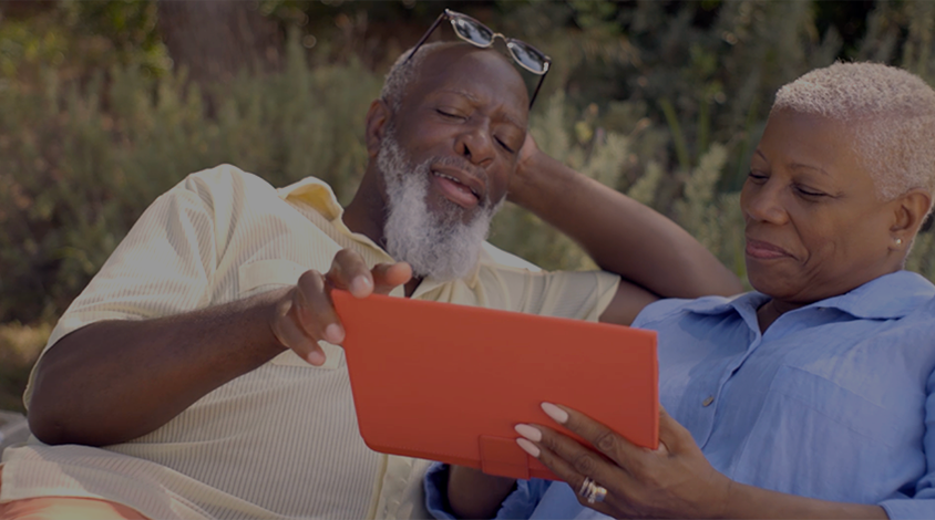 a couple relaxing and looking at an IPad
