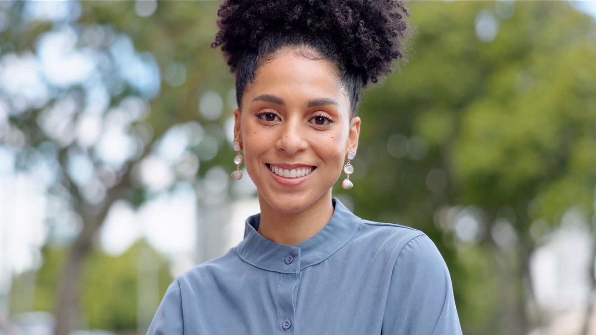 a smiling women with trees in the background